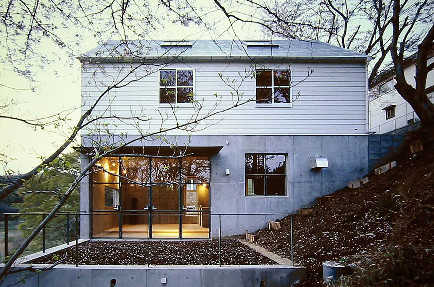 大磯　傾斜地の家　コンクリート打放と白い板張りの外観写真