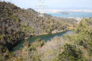 五石散策路の尾根山腹から長谷池を俯瞰する。奥は児島湾