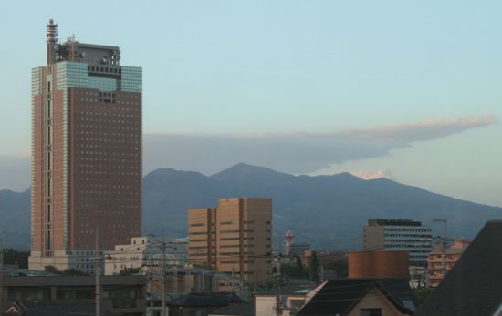 夕暮れの上毛線車窓から群馬県庁の奥に赤城山、中央に荒山、左に鍋割山